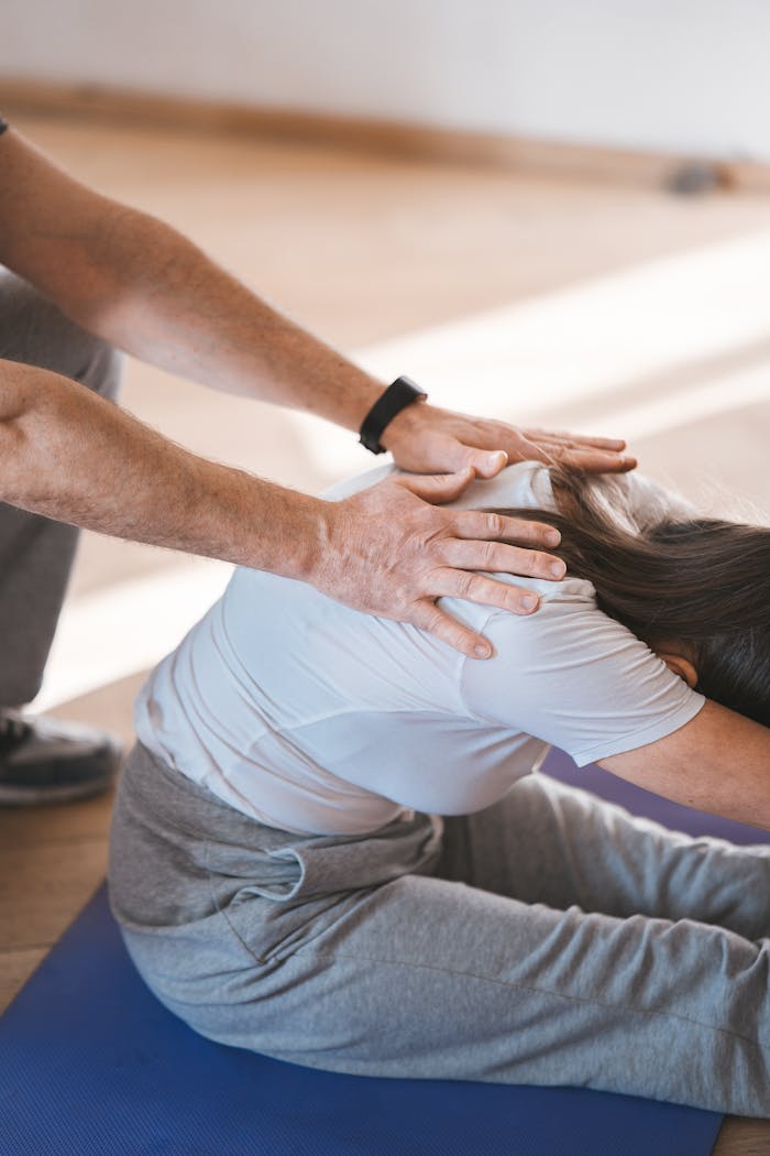 Crafting Captivating Headlines: Your awesome post title goes here Person stretching on a yoga mat with assistance indoors. Exercise and wellness concept.